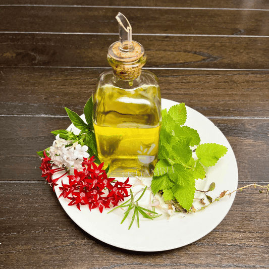 Freshly made rosemary and peppermint-infused hair oil with dried rose petals, ready for use on thinning hair