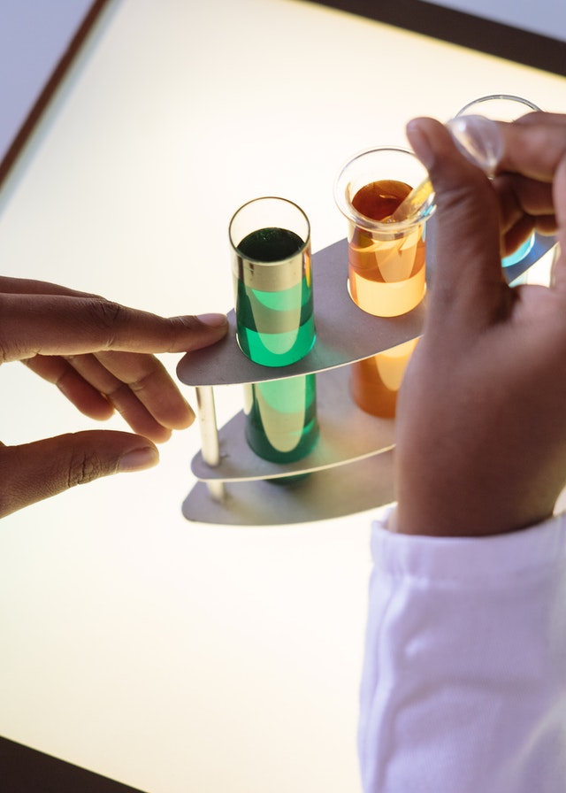 Colored Chemicals in test tubes with hand