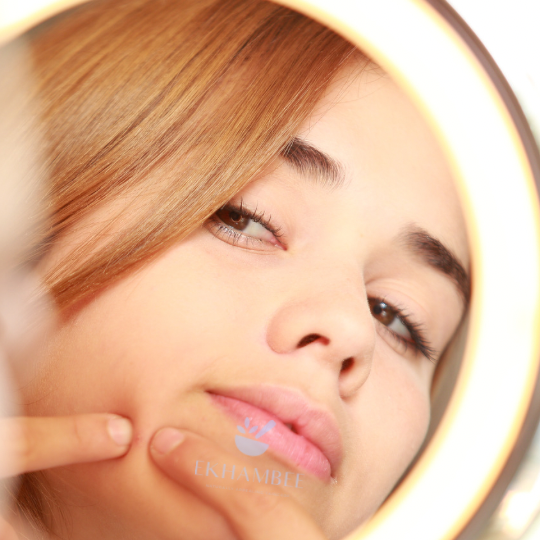 Woman squeezing a pimple on her face, which can lead to dark spots and scarring